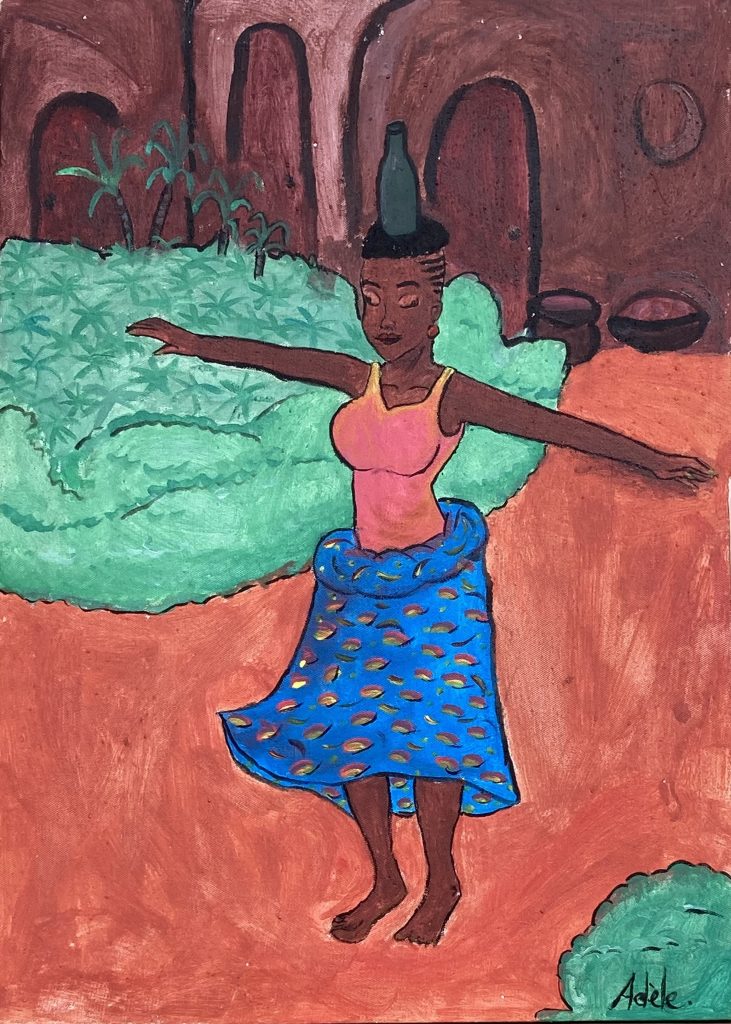 Femme en tenue traditionnelle qui danse avec une bouteille sur la tête. le sol est rouge comme de la terre battue entrecoupée de massifs de de verdure.